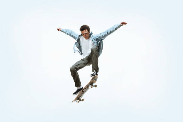 Caucasian young skateboarder riding isolated on a white background