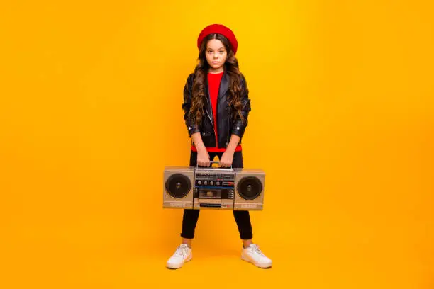Full length body size view of her she nice attractive trendy confident, long-haired girl in streetstyle holding in hands boombox isolated over bright vivid shine vibrant yellow color background