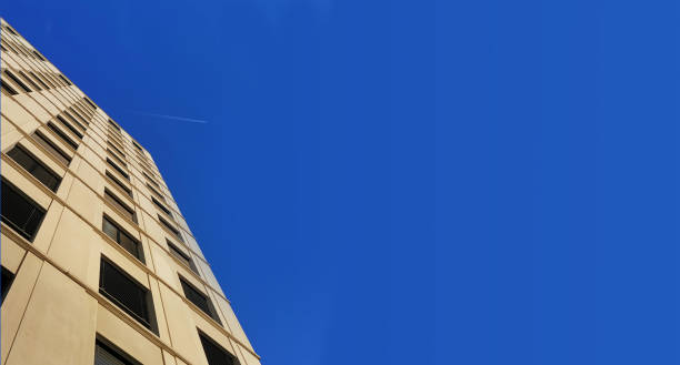 Shot of airplane flying above office buildings. stock photo