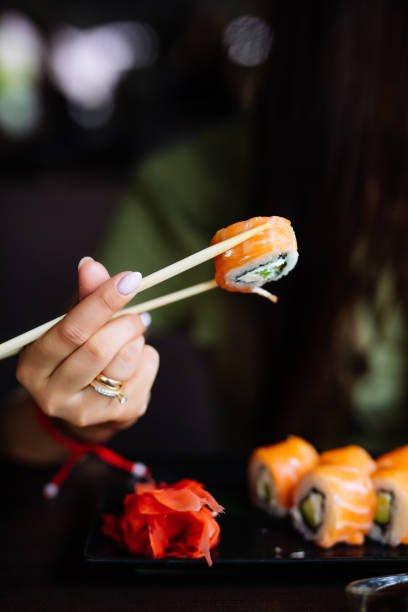 istock Hands eat sushi with chopsticks in cafe 1199879760