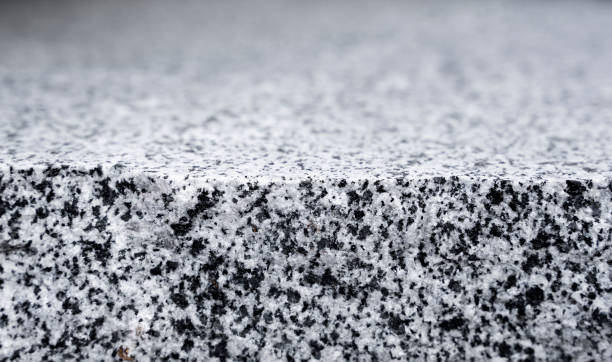 istock Natural stone grey granite background. Bright hard grey granite rock texture. Grey granite stone background. Grey granite untreated surface. 1199881945