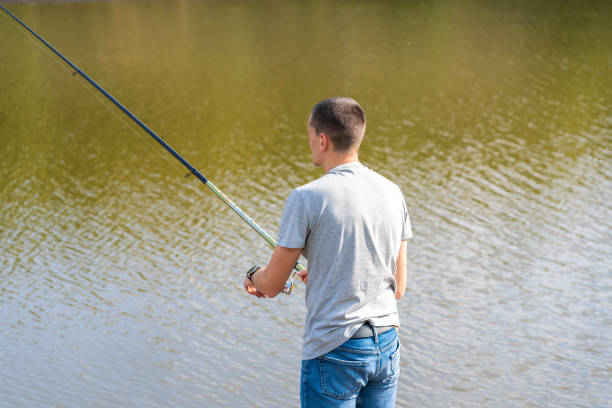 istock Man relaxing and fishing by lakeside a 1199883964