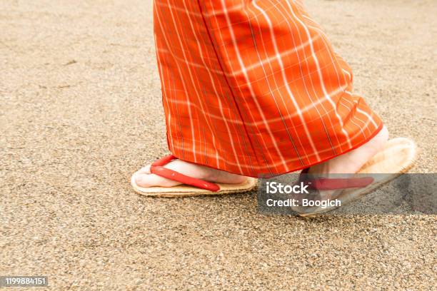 Feet Of Japanese Woman Walking Outdoors On A Dirt Road Stock Photo - Download Image Now
