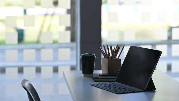 istock Side shot of workplace with notebook laptop and office equipment on comfortable work table in modern office. 1199884659