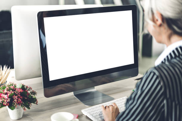 istock Business woman using computer with white mockup blank screens in modern work loft 1199885828