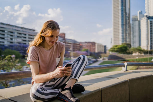 istock Young slim man using phone outdoors 1199886906