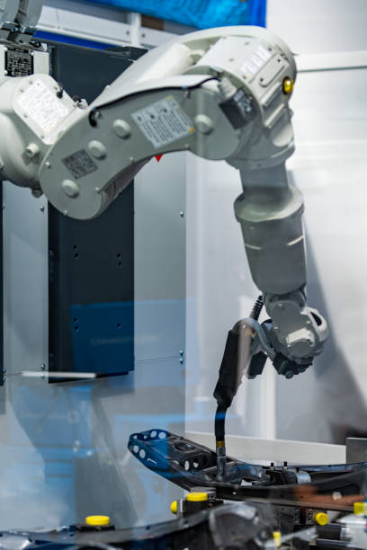istock Robotic arm welding system in a manufacturing production plant 1199887379