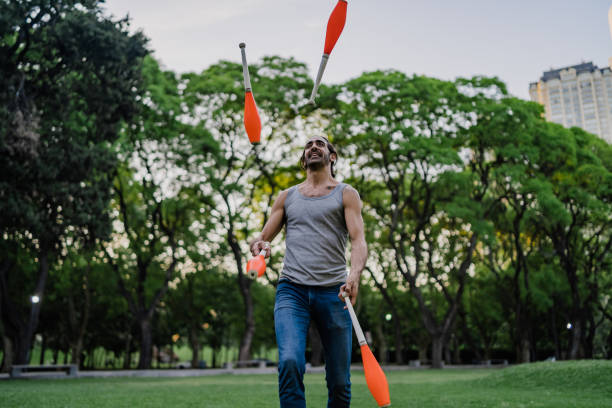 istock Man juggling with cones in park 1199887535