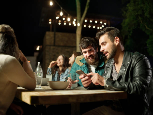 istock Joyful friends having a dinner party during the night 1199887999