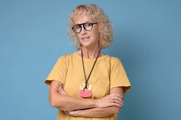 istock Woman is looking at camera and smiling with folded hands. 1199888021