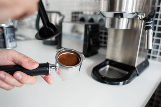 istock Guy prepare delicious aromatic coffee in a coffee machine. A simple way to make coffee 1199890990