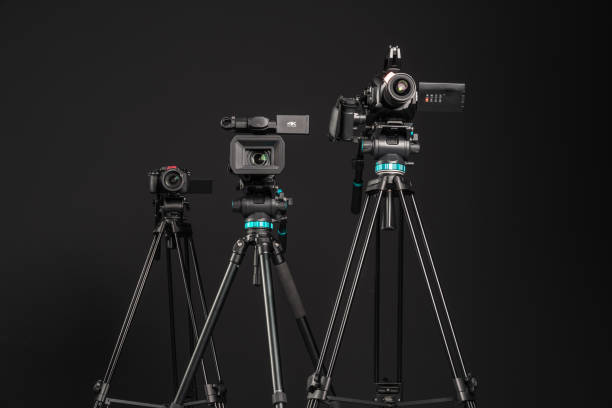 istock Three different types of video cinema photo camera on black background, low angle view 1199894331