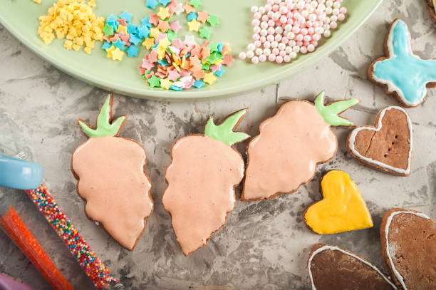The process of painting gingerbread with glaze. Flat lay cookie eggs. Handpainted gingerbread bunnies and eggs for Easter and copy space.