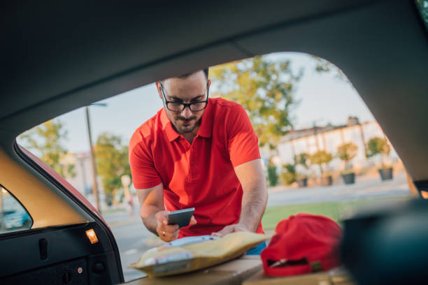 młody kurier w pracy - delivery van truck delivering moving van zdjęcia i obrazy z banku zdjęć