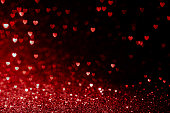 黒に赤い心のキラキラボケ、バレンタインデーのためのカード、クリスマスや結婚式のお祝い、愛のボケの光沢のある紙吹雪テクスチャテンプレートとバレンタインデーの背景