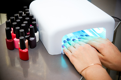 UV nail polish dryer in manicure salon, nail extension tools