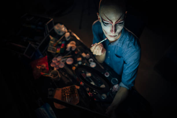 istock Male drag queen applying make-up dark dressing room 1199900612