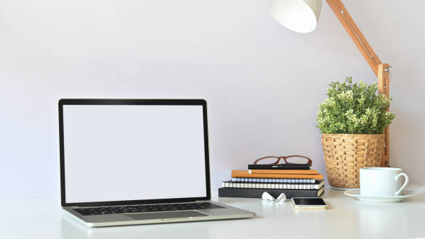 istock Blank screen laptop and office equipment is on the table. Modern working desk concept. 1199904003
