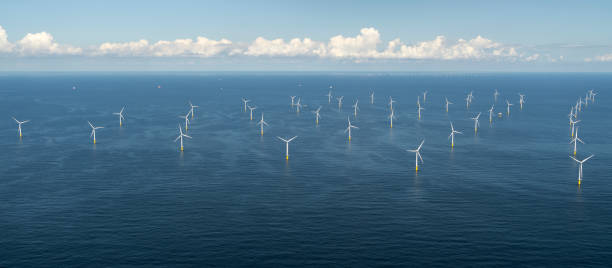 vista aérea do parque eólico off shore luchterduinen. os moinhos de vento estão no noordzee, a 20 quilômetros da costa holandesa entre noordwijk e zandvoort. no horizonte claro uma bela rua de nuvens. - north sea - fotografias e filmes do acervo