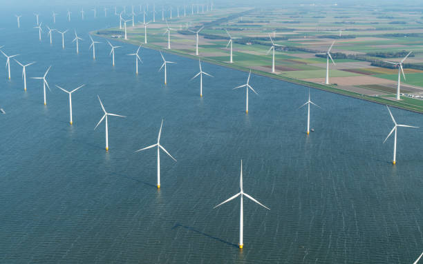 widok z lotu ptaka na farmę wiatrową na lądzie i na lądzie w noordoostpolder w holandii. wiatraki znajdują się nad jeziorem ijsselmeer flevoland, aby wytwarzać zieloną energię dla porozumienia klimatycznego paryż 2030 i 2050. - noordoostpolder zdjęcia i obrazy z banku zdjęć