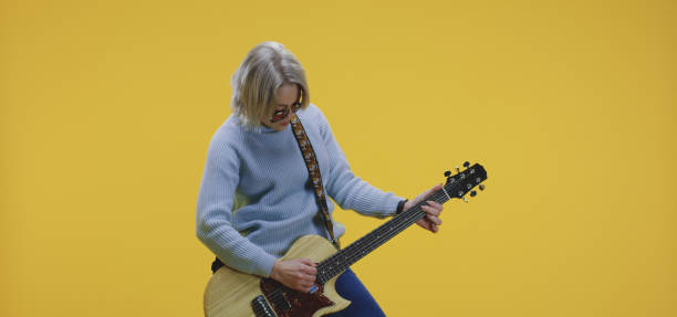 istock Young woman playing electric guitar 1199906122