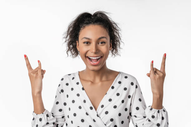 istock Young beautiful african american woman shouting with crazy expression doing rock symbol with hands up over isolated white background 1199906285