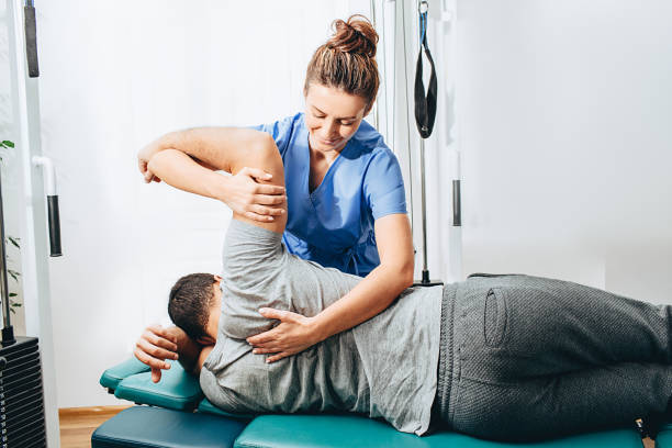 물리 치료사 치료 환자. 그녀는 환자의 손을 잡고, 어깨 관절 치료 - physical therapy men osteopath human age 뉴스 사진 이미지