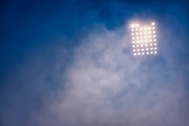 istock stadium lights and smoke against dark night sky background 1199908899