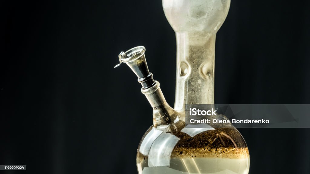 Close-up of dirty water bong on black background. Smoking cannabis with water pipe Close-up of dirty water bong on black background. Smoking cannabis with water pipe. Hemp is a concept of herbal medicine. Bong Stock Photo