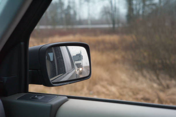 Flashing headlight of a truck in the back mirror, concept of safe driving