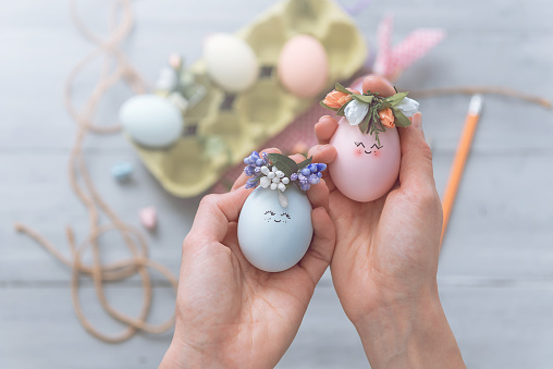 woman makes cute decorative eggs for easter holiday. do-it-yourself easter gifts concept. cute pastel colored eggs