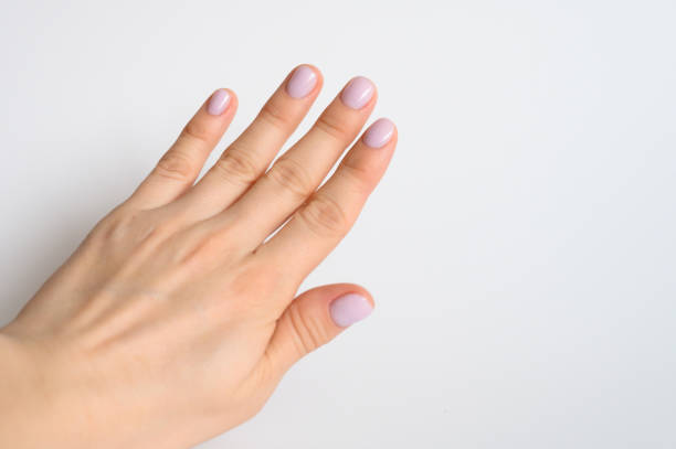 istock woman's hand with pale lilac painted nails on a white background 1199912556
