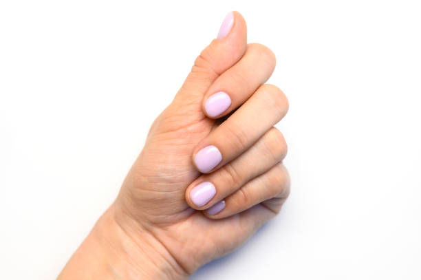 istock woman's hand with pale lilac painted nails on a white background 1199912688