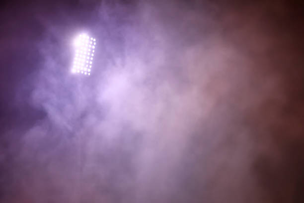 istock stadium lights and smoke against dark night sky background 1199913407