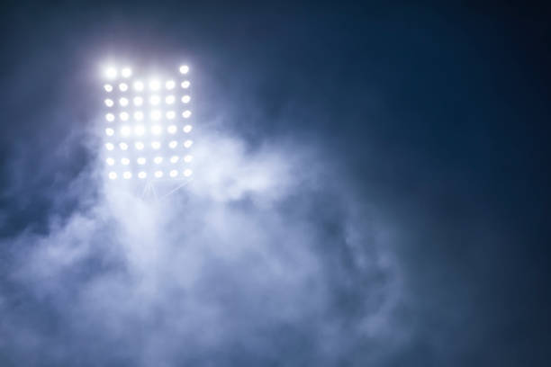 istock stadium lights and smoke against dark night sky background 1199916483
