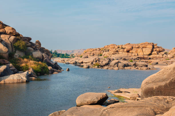 istock Ancient temple ruins near river in Hampi 1199917232