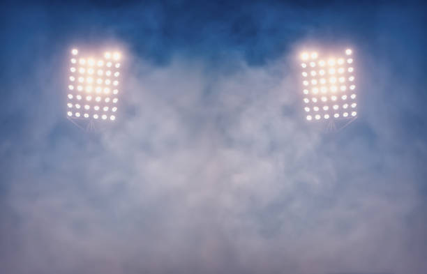 istock stadium lights and smoke against dark night sky background 1199917366