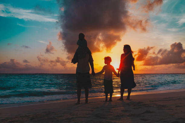 istock happy family with tree kids looking at sunset on beach 1199921486