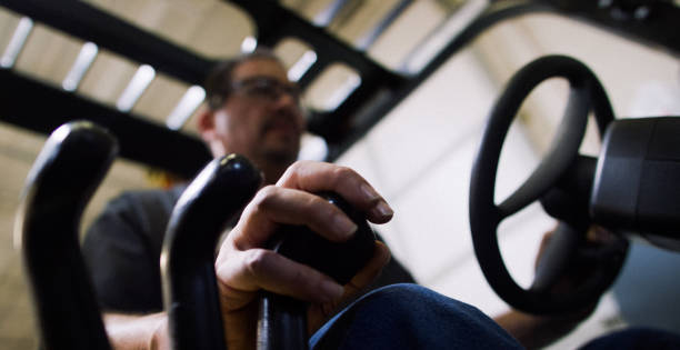 istock A Hispanic Forklift Operator in His Fifties Uses Handles to Control a Forklift in a Warehouse 1199922210