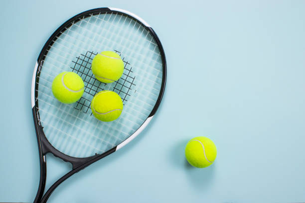 istock Tennis ball and racket isolated background. Top view 1199922525