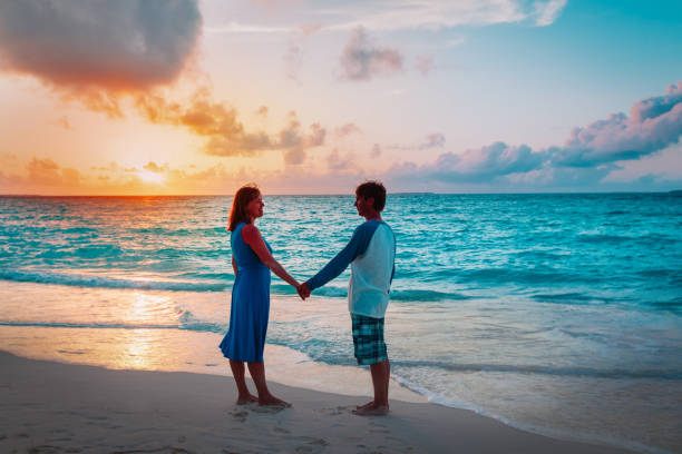 istock romantic loving couple holding hands at sunset beach 1199922841