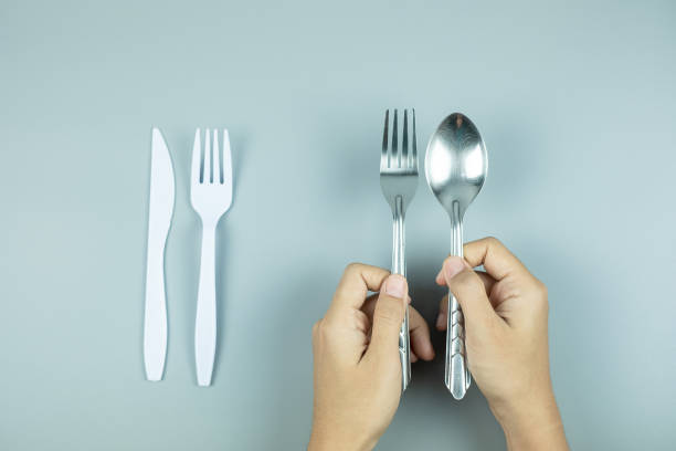 istock Man holding Stainless Steel spoon and fork over white plastic tool. Environmental Protection, Zero waste, Reusable, Say No Plastic, World Environment day and Earth day concept 1199923858
