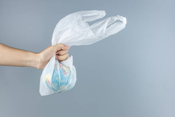istock Man holding plastic bag and Globe inside against gray background with Copy space for text. Environmental Protection, Zero waste, Reusable, Say No Plastic, World Environment day and Earth day concept 1199924074