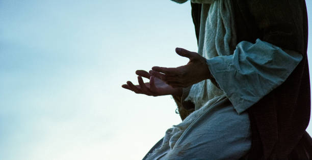 человек, нося традиционный религиозный одежды на коленях и молится с ладонями на открытом воздухе на восходе / закате на открытом воздухе (и - praying men god kneeling стоковые фото и изображения