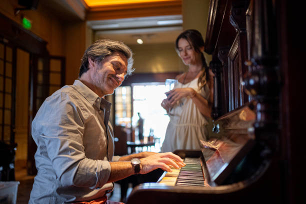 istock Handsome man playing a piano for his wife at a restaurant 1199925746