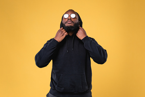 Portrait of serious beard African American man with dark sunglasses in studio