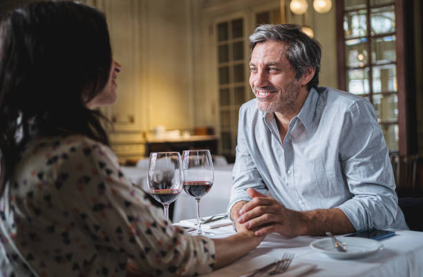 istock Flirting couple holding hands at a restaurant during Valentine's day 1199926487