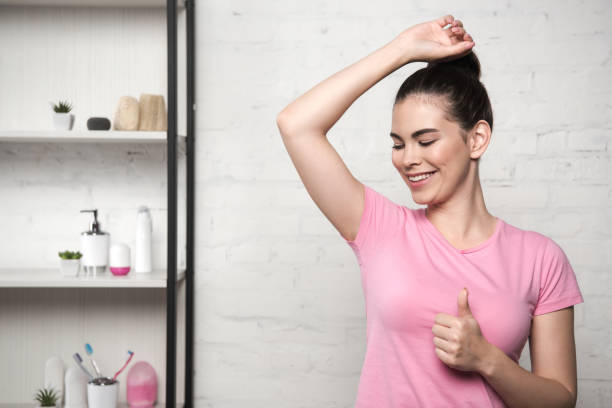 istock smiling woman showing thumb up while looking at underarm 1199927931