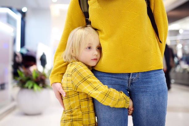 le petit garçon embrasa sa mère. la timidité, les peurs, l'anxiété. - timide photos et images de collection