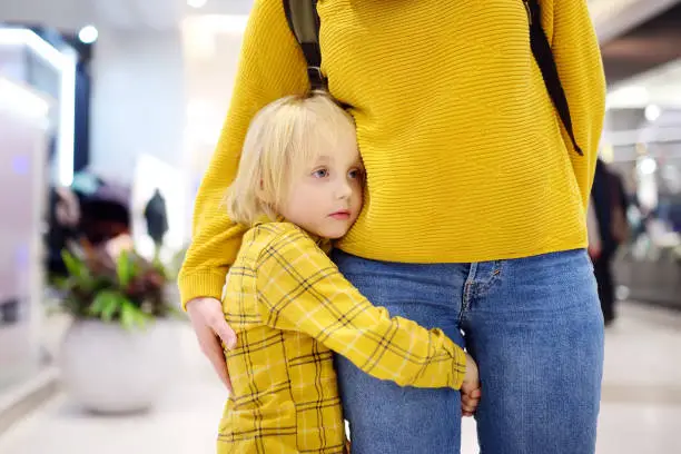 Little boy embrased his mother. Shyness, fears, anxiety. Hyper-attachment to mother.